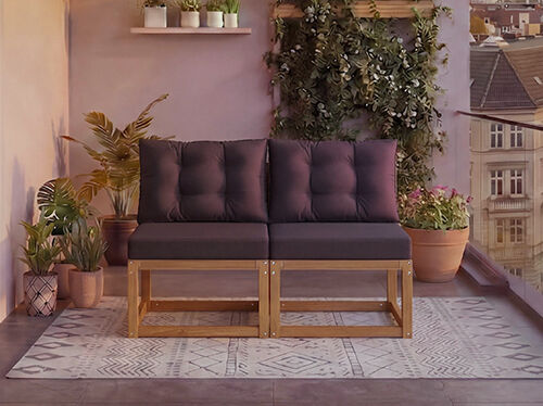 Dvoседežna modularna lesena sedežna garnitura s temno sivimi blazinami na balkonu, obkroženem s sobnimi rastlinami in pogledom na mesto v ozadju